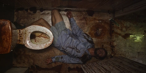 Glorious; Wes (Ryan Kwanten) lying in the muck of a roadside bathroom stall..