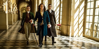 The King's Daughter; King Louis XIV walks the halls of Versailles accompanied by Jean-Michel Lintillac (Ben Lloyd-Hughes) and Doctor Labarthe (Pablo Schreiber).